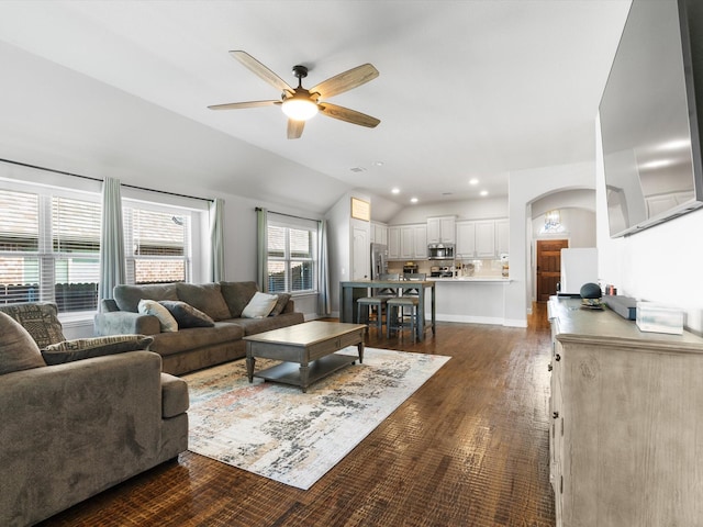living area featuring ceiling fan, lofted ceiling, arched walkways, dark wood-type flooring, and recessed lighting