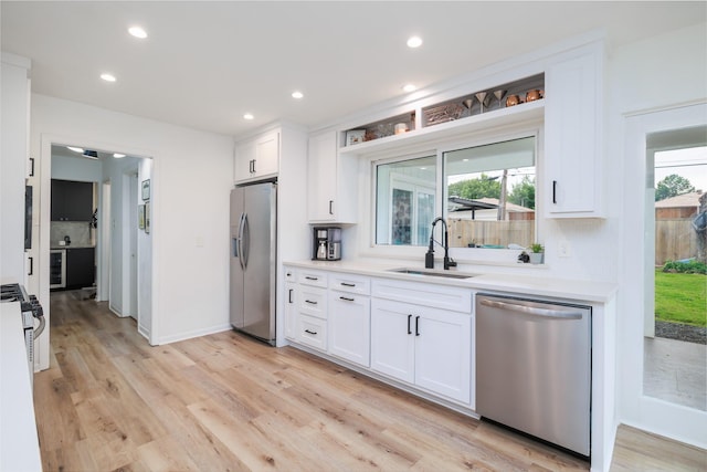 4940 Ashbrook Rd, Dallas, TX 75227 - kitchen with appliances with stainless steel finishes, a sink, white cabinets, light countertops, and recessed lighting