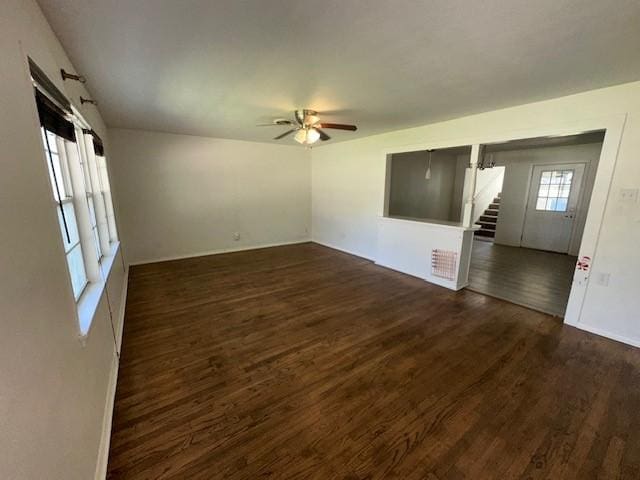 unfurnished room with stairs, wood finished floors, ceiling fan, and baseboards