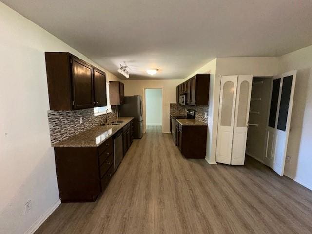 kitchen featuring light wood-style floors, electric stove, dark brown cabinetry, decorative backsplash, and freestanding refrigerator