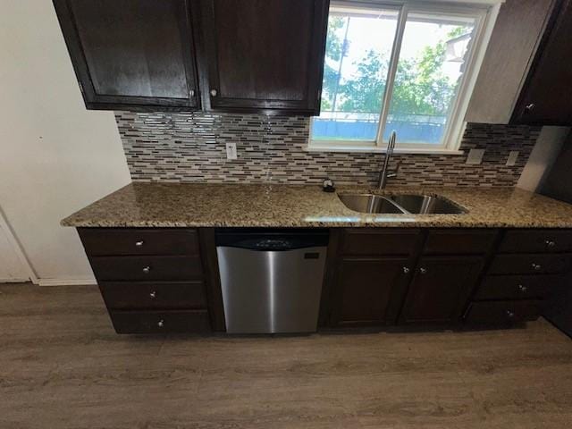kitchen featuring dishwasher, a sink, light wood-type flooring, tasteful backsplash, and dark brown cabinetry