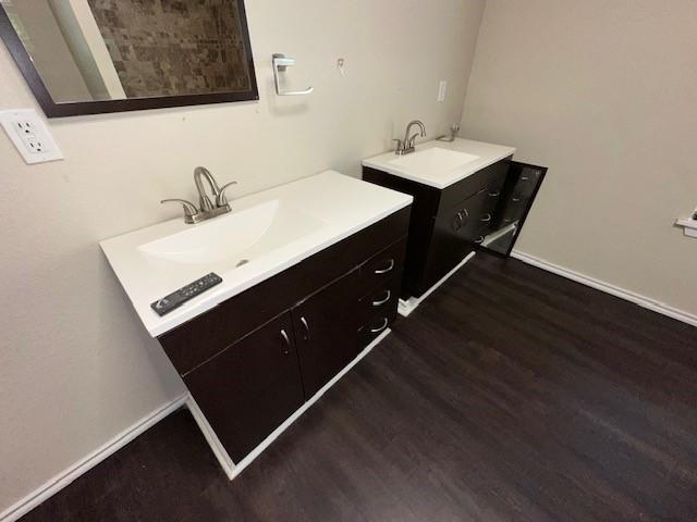 bathroom with vanity, wood finished floors, and baseboards
