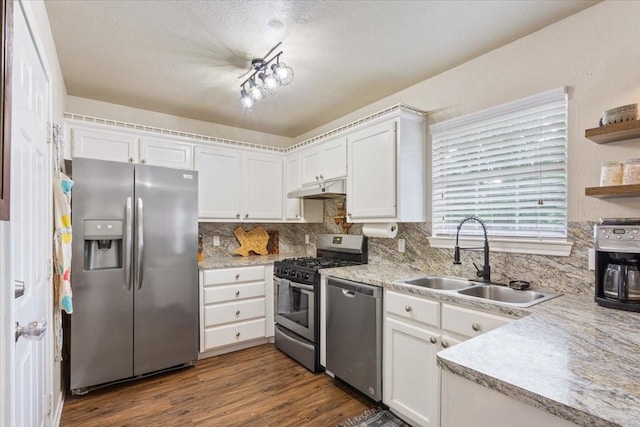 401 Mahon Hollow Dr, Waco, TX 76704 - kitchen featuring stainless steel appliances, a sink, under cabinet range hood, backsplash, and white cabinets