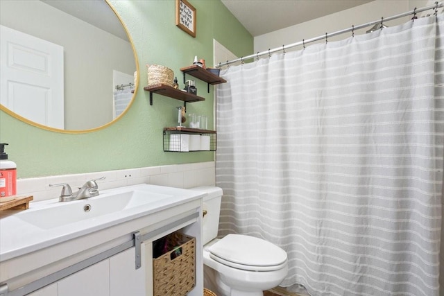 401 Mahon Hollow Dr, Waco, TX 76704 - full bathroom with toilet, tile walls, vanity, a wainscoted wall, and a shower with shower curtain