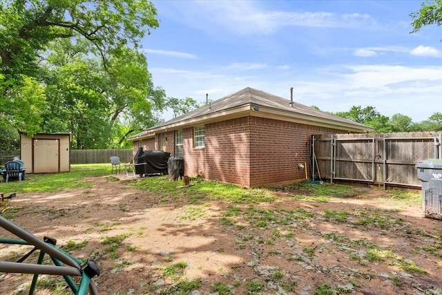 401 Mahon Hollow Dr, Waco, TX 76704 - back of property featuring brick siding, a shed, a fenced backyard, and an outbuilding