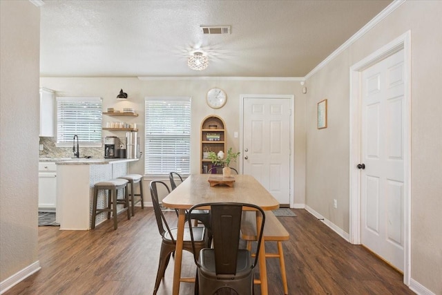 401 Mahon Hollow Dr, Waco, TX 76704 - dining area featuring dark wood-style floors, crown molding, baseboards, and a textured ceiling