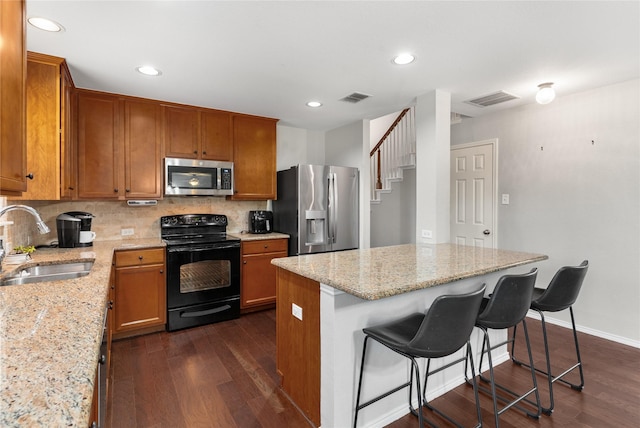 1915 Fairway Crossing Rd, Wylie, TX 75098 - kitchen with appliances with stainless steel finishes, a sink, a kitchen island, brown cabinets, and recessed lighting
