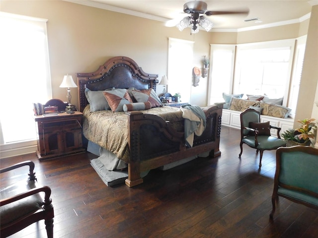 bedroom featuring dark wood-type flooring, ornamental molding, and a ceiling fan