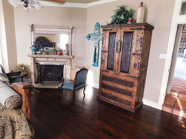 sitting room featuring hardwood / wood-style floors, crown molding, a fireplace, and baseboards