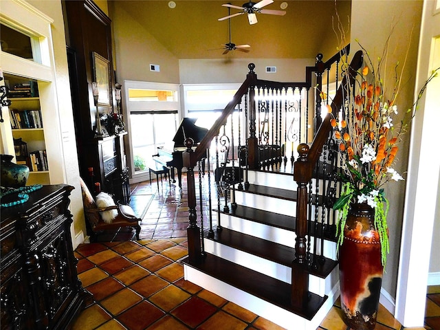 staircase with a ceiling fan, tile patterned flooring, lofted ceiling, and baseboards