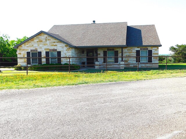 view of front facade featuring stone siding and an exterior structure