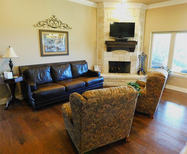 living room with ornamental molding, baseboards, dark wood-style floors, and a stone fireplace