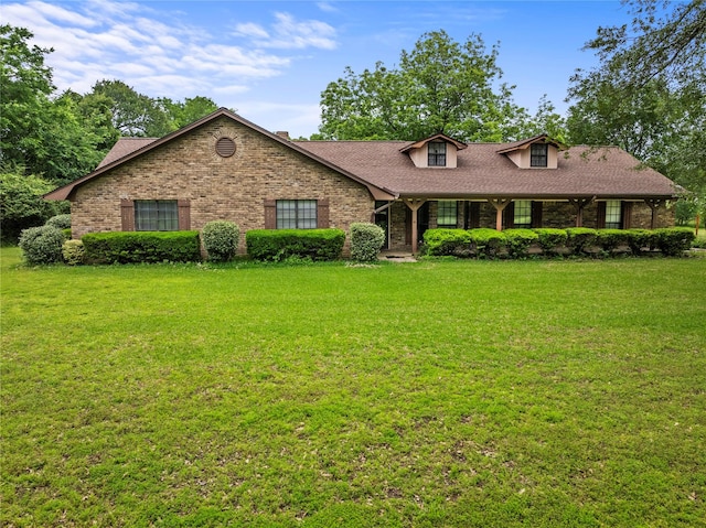 979 Rockdale, Sulphur Springs, TX 75482 - view of front of house featuring a front yard, brick siding, a shingled roof, and a porch
