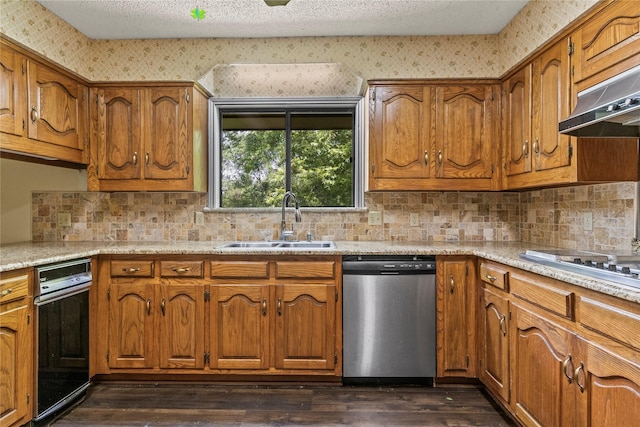 979 Rockdale, Sulphur Springs, TX 75482 - kitchen with stainless steel dishwasher, a sink, brown cabinets, and a textured ceiling