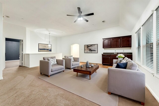 305 Blythe Bridge Dr, Roanoke, TX 76262 - living area featuring vaulted ceiling, a ceiling fan, arched walkways, baseboards, and light colored carpet