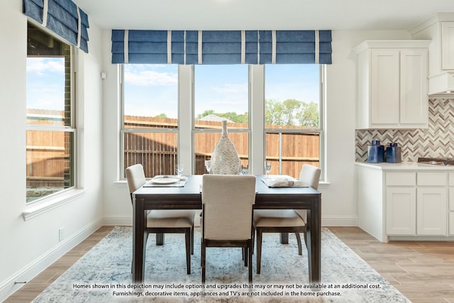 dining space with baseboards, a healthy amount of sunlight, and light wood-style floors