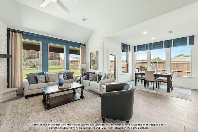 living room featuring vaulted ceiling, visible vents, wood finished floors, and ceiling fan