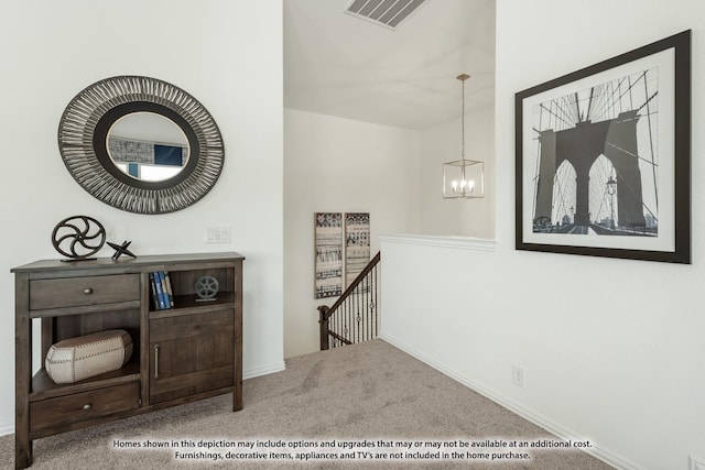 interior space with baseboards, an upstairs landing, visible vents, carpet flooring, and a notable chandelier
