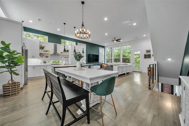 dining room featuring recessed lighting, a chandelier, light wood-style flooring, and a ceiling fan
