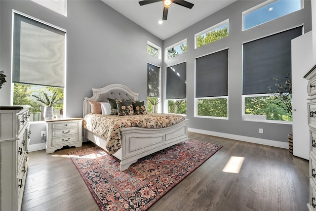 bedroom with wood finished floors, baseboards, ceiling fan, and high vaulted ceiling