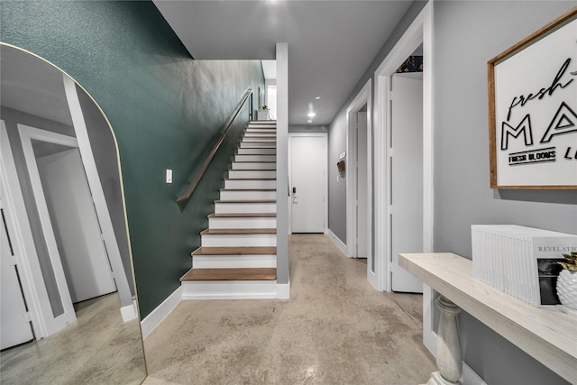 stairway with concrete floors, baseboards, and recessed lighting