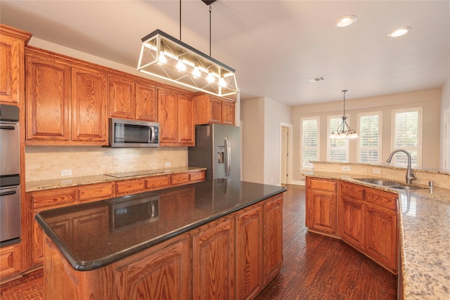 4016 Muscovy Dr, Mckinney, TX 75072 - kitchen with a sink, appliances with stainless steel finishes, decorative backsplash, recessed lighting, and brown cabinetry