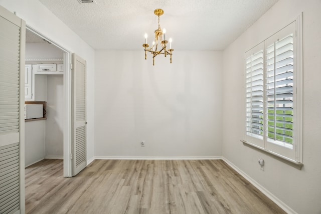 614 Willowbrook Cir, Duncanville, TX 75116 - unfurnished bedroom with light wood-type flooring, a chandelier, a textured ceiling, and baseboards