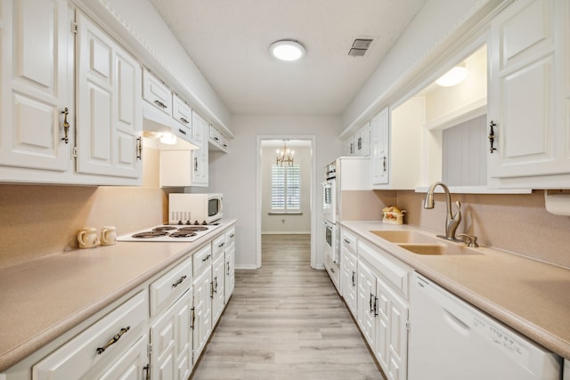 614 Willowbrook Cir, Duncanville, TX 75116 - kitchen with a sink, white appliances, white cabinets, and light countertops