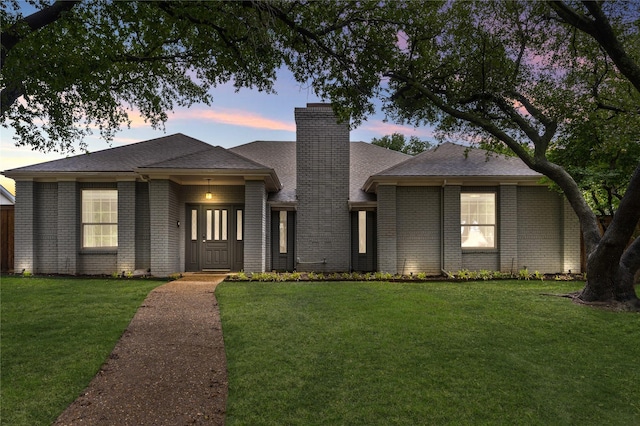 7610 Bantry Cir, Dallas, TX 75248 - view of front of house featuring a chimney, a front yard, roof with shingles, and brick siding