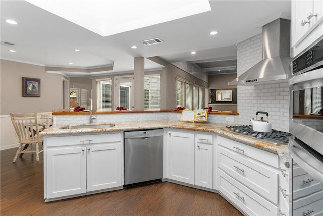 7610 Bantry Cir, Dallas, TX 75248 - kitchen featuring appliances with stainless steel finishes, wall chimney exhaust hood, a sink, decorative backsplash, and recessed lighting