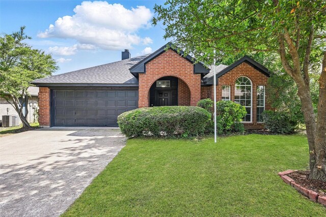 view of front of home featuring brick siding, a front lawn, an attached garage, driveway, and roof with shingles