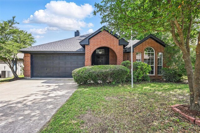 view of front of house featuring brick siding, a garage, driveway, a shingled roof, and a chimney