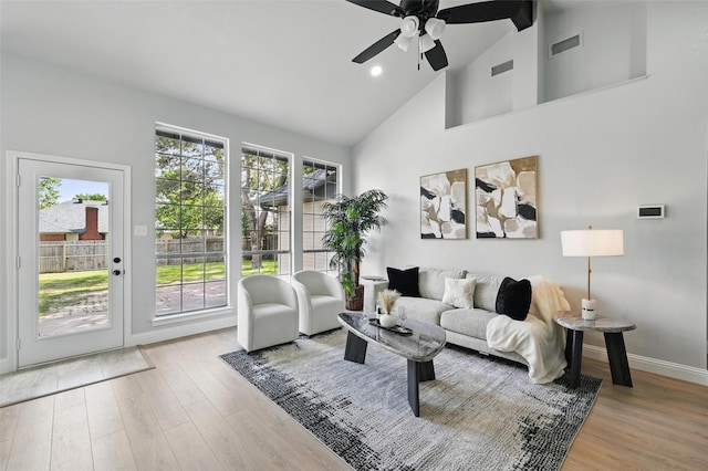 living room featuring high vaulted ceiling, a ceiling fan, wood finished floors, healthy amount of natural light, and baseboards
