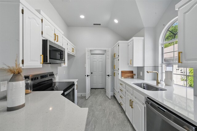 kitchen with stainless steel appliances, a sink, white cabinets, baseboards, and light stone countertops