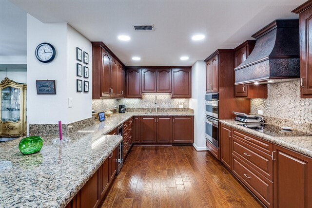 kitchen with black electric stovetop, custom exhaust hood, a sink, light stone countertops, and dark wood-style flooring