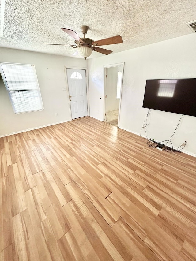 3601 Avenue N, Fort Worth, TX 76105 - unfurnished living room with light wood finished floors, a ceiling fan, and a textured ceiling