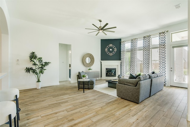 2406 Capitol Pl, Melissa, TX 75454 - living area featuring a ceiling fan, light wood finished floors, a high end fireplace, and arched walkways