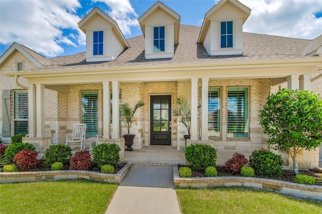 2406 Capitol Pl, Melissa, TX 75454 - property entrance with covered porch, brick siding, a shingled roof, and stone siding