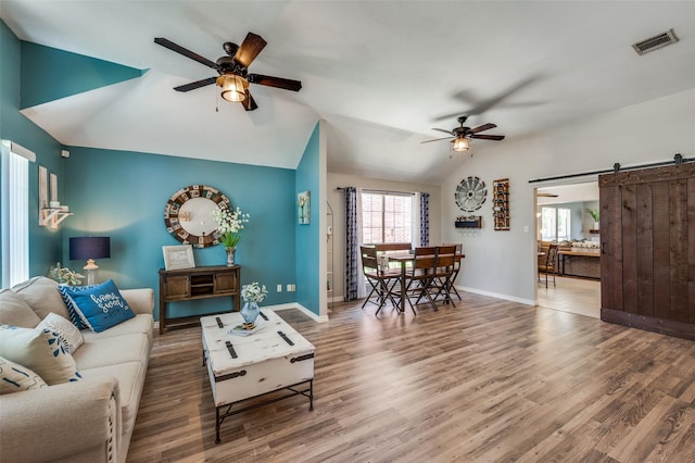 1361 Daffodil Ln, Lewisville, TX 75077 - living area featuring a ceiling fan, lofted ceiling, wood finished floors, a barn door, and baseboards