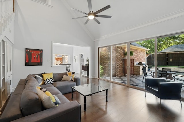 living area featuring high vaulted ceiling, wood finished floors, a ceiling fan, and crown molding