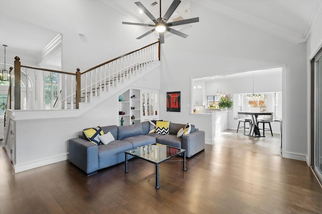 living room featuring crown molding, stairway, plenty of natural light, wood finished floors, and baseboards