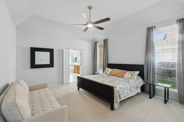 bedroom featuring light colored carpet, baseboards, vaulted ceiling, ceiling fan, and connected bathroom