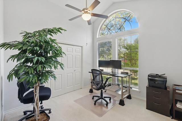 carpeted home office with high vaulted ceiling, ceiling fan, and baseboards