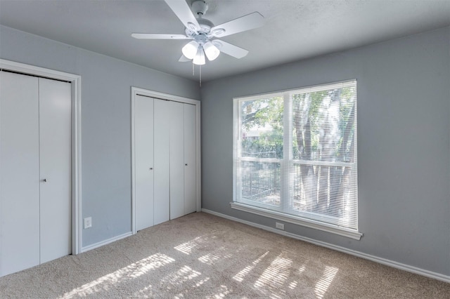 8721 N Normandale St, Fort Worth, TX 76116 - unfurnished bedroom featuring carpet flooring, two closets, baseboards, and a ceiling fan