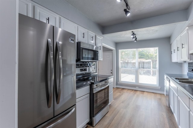 8721 N Normandale St, Fort Worth, TX 76116 - kitchen with appliances with stainless steel finishes, track lighting, white cabinets, and light wood-style flooring