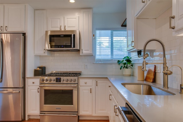 1205 Ranier St, Dallas, TX 75208 - kitchen featuring stainless steel appliances, a sink, white cabinetry, and recessed lighting