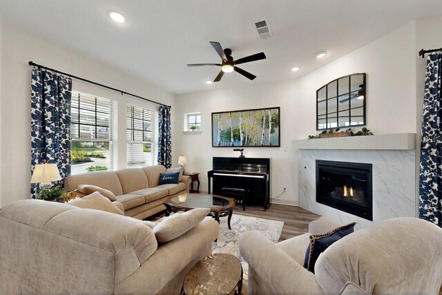 living room featuring wood finished floors, a ceiling fan, a high end fireplace, and recessed lighting