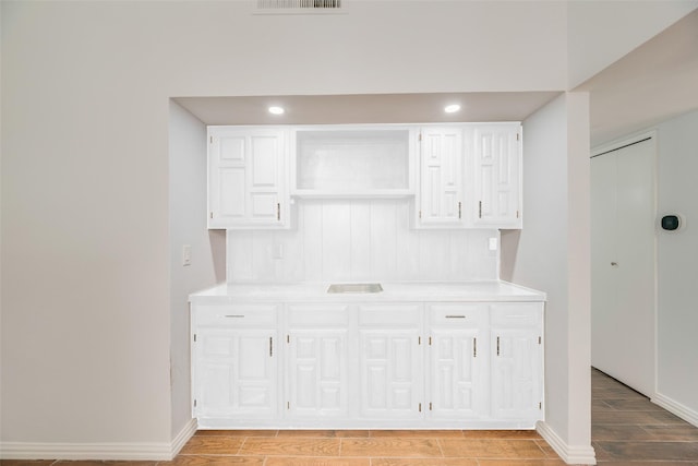 3243 Weather Vane Ln, Dallas, TX 75228 - kitchen featuring wood finish floors, light countertops, and white cabinets