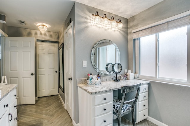 1420 Clearwater Ct, Grapevine, TX 76051 - bathroom with baseboards, vanity, a textured wall, and parquet flooring