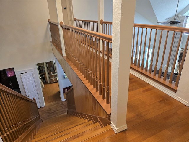 1910 Roselle Ct, Arlington, TX 76018 - stairs featuring wood finished floors, a ceiling fan, and a towering ceiling
